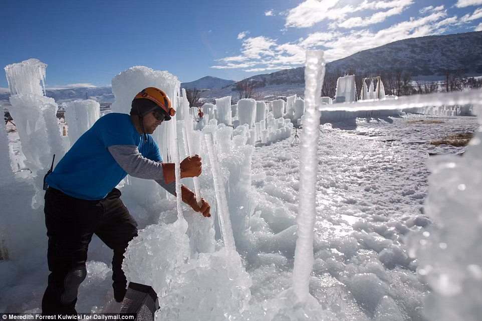 Một công nhân sử dụng các cột băng và tuyết tan để tạo những bức tường ban đầu cho lâu đài.