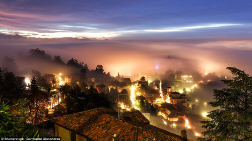 Khung cảnh đẹp mê đắm khi sương mù bao phủ một phần thành phố Bergamo ở Italia vào ban đêm.