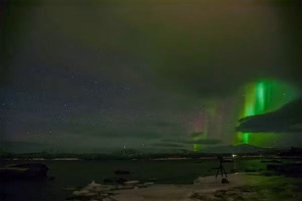 Những tia sáng rọi thẳng xuống dưới đất, tách biệt với một bầu trời đầy sao.