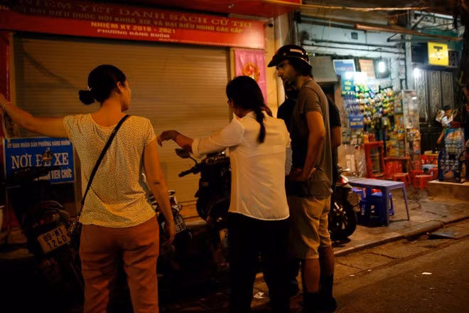 Tại một điểm gửi xe trên phố Mã Mây, du khách nước ngoài đang tranh cãi về giá gửi với người trông xe do giá quá cao.