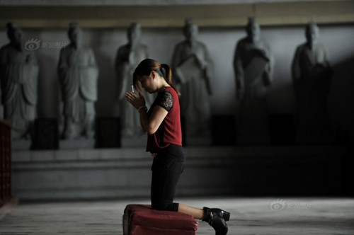 Tại Phúc Châu, một phụ huynh cầm bút quỳ trong đền Khổng tử đề cầu nguyện cho con mình tham gia kỳ thi đại học gặp may mắn, suôn sẻ.