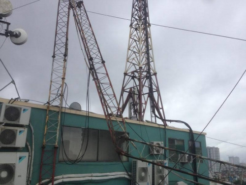 Tin tức mới nhất liên quan đến vụ việc cột thu phát sóng tại tòa nhà Ford Thăng Long (địa chỉ 105 Láng Hạ, quận Đống Đa, Hà Nội) bị gãy đổ khiến 1 người thiệt mạng, ghi nhận của PV tại hiện trường cho thấy, tòa nhà cao 10 tầng, cột thu phát sóng “tử thần” được đặt trên nóc của tòa nhà.