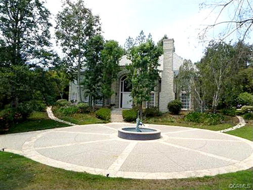 Toàn cảnh biệt thự dát vàng trị giá hàng trăm tỷ của ngôi sao võ thuật Thành Long tại Beverly Hills. Trước nhà có một đài phun nước làm trung tâm.