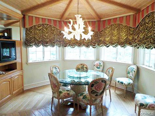 Phòng ăn mềm mại hơn với bàn kính tròn và ghế đệm bọc vải hoa xinh xắn.