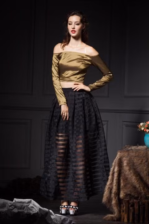 Hoặc bạn cũng có thể đánh lạc hướng điểm nhìn với bờ vai trần gợi cảm và vòng eo con kiến. Áo crop top dài tay trễ vai gợi cảm phối với chân váy dài chất liệu voan mỏng giúp bạn trở thành một quý cô vừa cổ điển, vừa gợi cảm, quý phái và sang trọng.