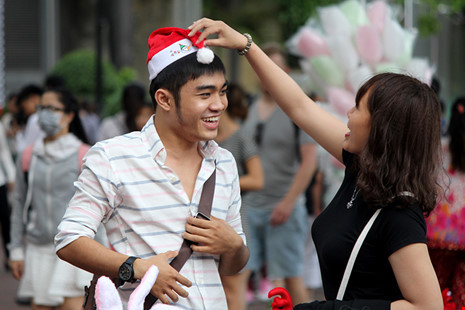 Đôi bạn trẻ sắm nón Giáng sinh xuống phố.