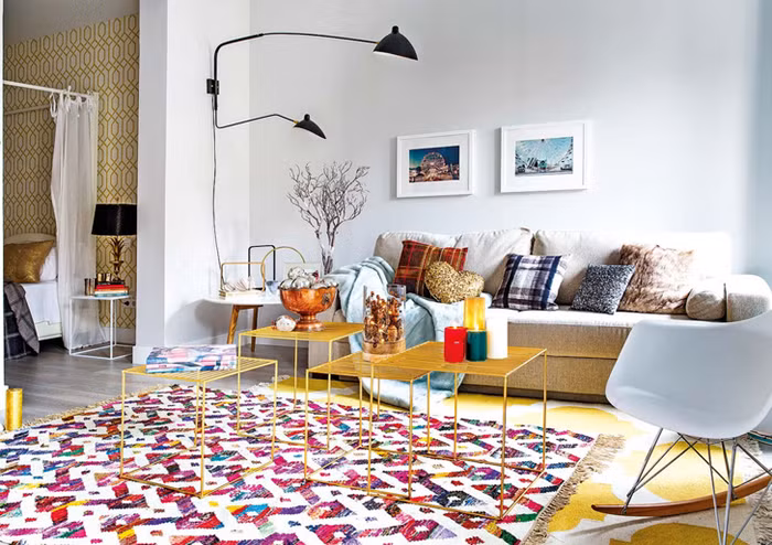 Để không gian phòng khách luôn tỏa ra một năng lượng tích cực, mang lại niềm vui, sự thích thú cho mọi người khi sử dụng, các kiến trúc sư thiết kế đã chọn khoảng diện tích thoáng sáng, ưa nhìn nhất của căn hộ để bố trí khoảng chức năng vô cùng quan trọng này. Phòng khách được chọn gam màu trắng làm màu nền, giúp những màu nhấn của thảm trải sàn, của những vật dụng trang trí trở nên nổi bật và đáng yêu hơn. Và quan trọng là sự hiện diện của mảng xanh ngọc lam, đủ để không gian thêm hiện đại và hút mắt.