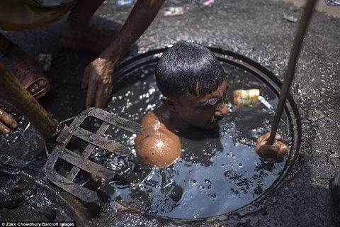 Ông ta không được trang bị bất cứ đồ bảo hộ lao động nào, phải ngụp lặn trong nước cống đen xì để làm thông dòng chảy