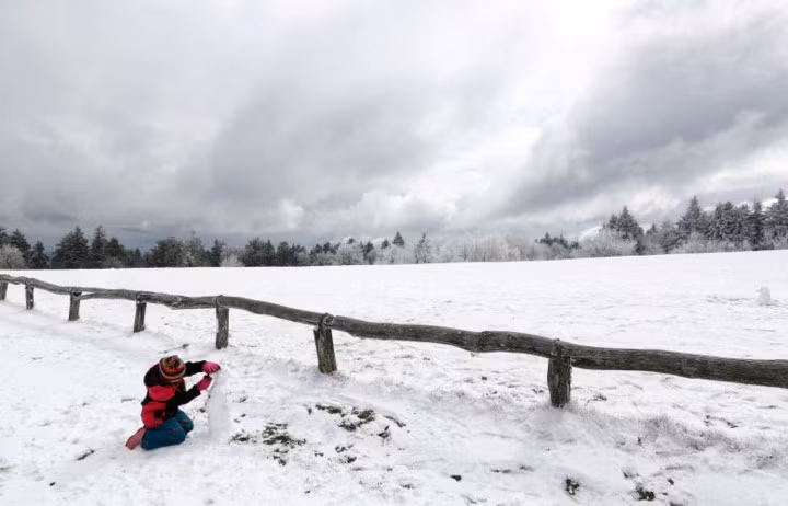 Một đứa trẻ thích thú chơi trò chơi với tuyết trên đỉnh núi Feldberg ở ngoại vi Frankfurt, Đức.