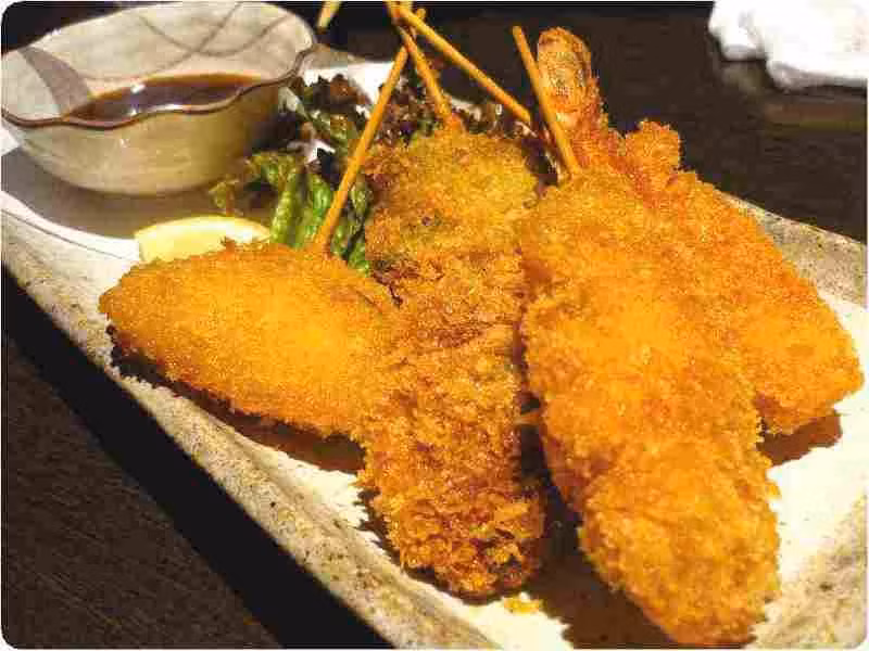 3. Kushikatsu: Đây là loại đồ nướng xiên gồm thịt và rau quả của vùng Kansai. Nhà hàng Kushinobo ở trong ga Kyoto, trên tầng thượng khu mua sắm Isetan có phục vụ set ăn kushikatsu vào buổi trưa. Món nướng xiên này được gọi là konnyaku, chỉ nướng khi có yêu cầu, gồm ớt shishito nhồi gà băm, hành, trứng cút, bí đỏ… Món ăn đặc sản này được ăn kèm cơm, súp miso và trà. Ảnh: Youinjapan.