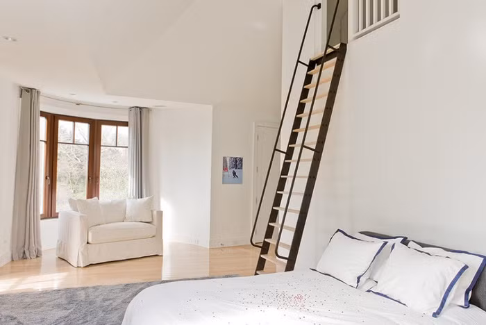 Bên cạnh giường ngủ là cầu thang nhỏ xinh với chất liệu kim loại tổng hợp. Với không gian chật chội, chủ nhân của ngôi nhà đã chọn lựa cách thiết kế cầu thang với kiểu dáng đơn giản, tiện dụng. Cách thiết kế đơn giản, bố trí hài hòa giúp tăng thêm diện tích sử dụng cho không gian nhỏ.