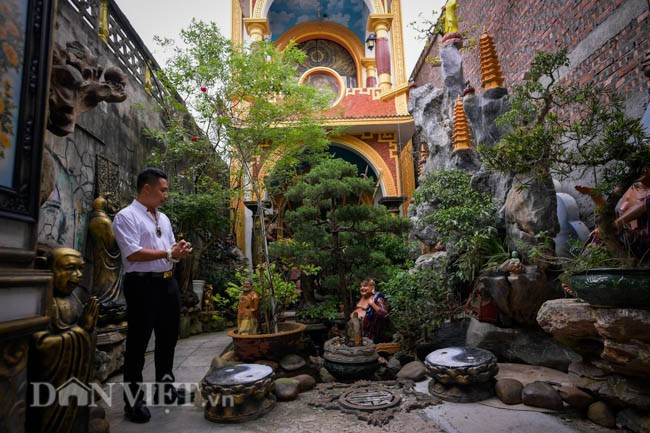 Sân của biệt thự "kỳ dị" này có một hồ nước róc rách, trên đó được anh dựng thành một quả núi nặng 20 tấn từ 5 loại đá, sỏi lấy ở 5 vùng khác nhau, thả 100 con cá chép vàng bơi xung quanh và trồng nhiều cây cối. Ảnh: Dân Việt.