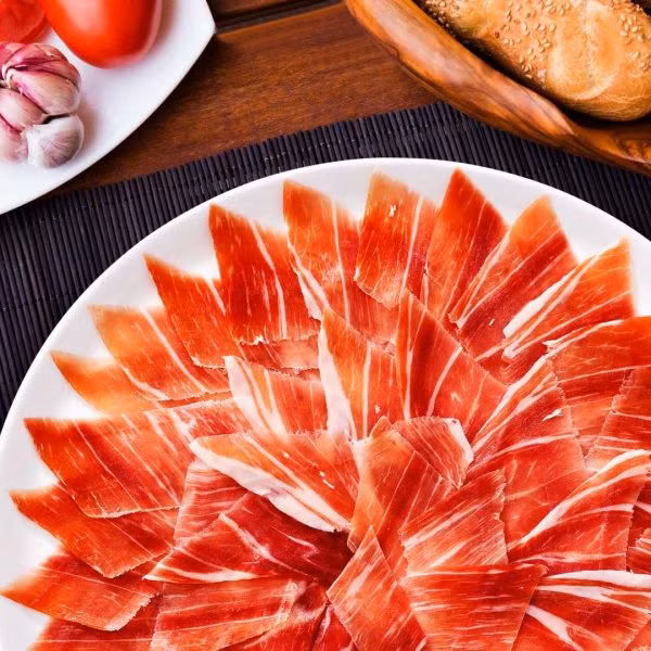 Đùi lợn muối Iberico có vị rất đặc biệt. Phần thịt nạc được thái thành lát mỏng để ăn trực tiếp. Ảnh: Kenko.