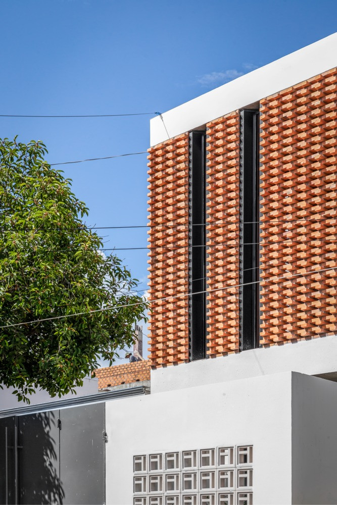 Ấn tượng nhất là mặt tiền xây bằng gạch nung tại địa phương. Còn bức tường trắng được sử dụng để giảm sự hấp thụ ánh sáng mặt trời.