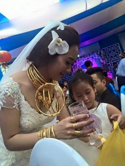 Ngày 17/4/2015, dư luận xôn xao trước hình ảnh cô dâu ở Hà Tĩnh đeo đầy vàng gồm kiềng, lắc, dây chuyền, nhẫn... đến mức có người nói hơi quá rằng "không còn chỗ đeo". Ảnh: Internet.