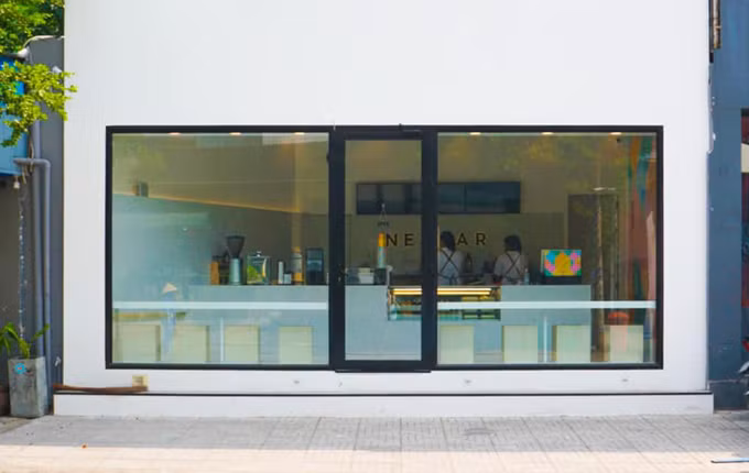 Quán mang phong cách tối giản, bảng hiệu cũng rất đơn giản và gọn gàng, chỉ chứa được 10 khách, phục vụ đồ ăn lành mạnh như salad, sandwich và nước ép.