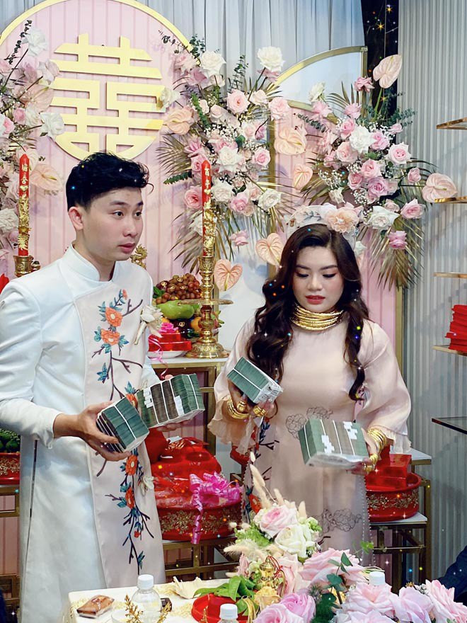 Cùng với đó là hình ảnh cả cô dâu và chú rể đang cầm trên tay những cọc tiền lớn toàn tờ 500.000 đồng. Ảnh: GDTĐ