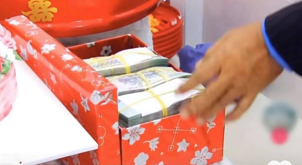 Trong năm 2020, cộng đồng mạng cũng xôn xao trước màn trao tiền nạp tài "cực khủng" của một cặp đôi đến từ miền Tây. Theo đó, nhà trai đưa số tiền nạp tài là 1 tỷ 800 triệu và thêm 100 triệu, nhà trai xin góp phần phụ vào bữa tiệc. Ảnh: Saostar.