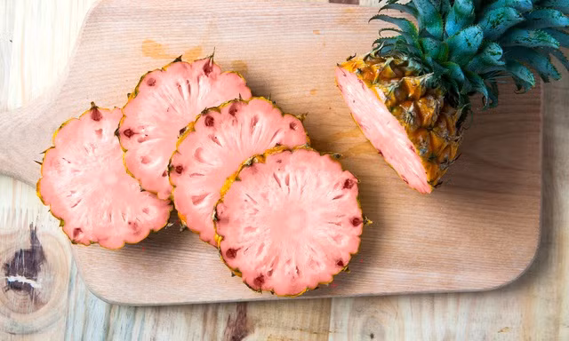 Dự án này khởi động năm 2005, được Cục quản lý Thực phẩm và Dược phẩm Mỹ phê duyệt năm 2016, và mất thêm 4 năm để có thể hoàn thiện. Loại dứa này được đặt tên là Pinkglow.