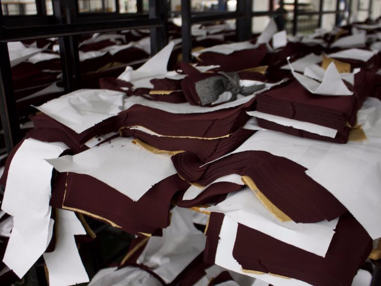 Vải được đặt dưới máy cắt. Với loại vải mỏng, máy có thể cắt 200 lớp cùng một thời điểm.