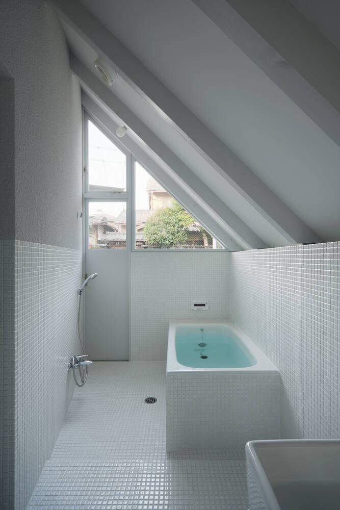 Phòng tắm được ốp toàn bộ gạch trắng tráng men, vừa đẹp mắt, vừa dễ vệ sinh. Nguồn ảnh: Archdaily.