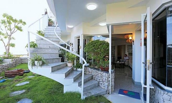 Tầng dưới gồm hai căn hộ và sân vườn kết nối với tầng trên qua một cầu thang lộ thiên. Ảnh: CL&amp;XH.