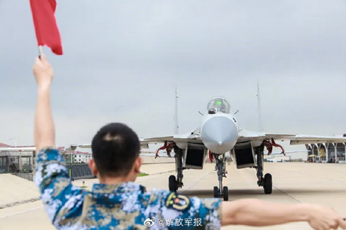 Truyền thông Trung Quốc vừa cho đăng tải một hình ảnh huấn luyện tiêm kích hạm J-15 của nước này. Điều đáng nói là ở góc bên phải khung hình, phần đuôi của một chiếc máy bay lạ, đã vô tình lọt vào ống kính.