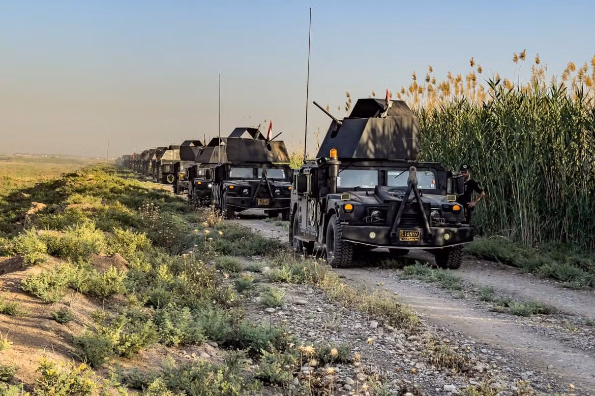 Đoàn xe tải, xe bọc thép humvee và xe chở lính đặc nhiệm Iraq di chuyển qua vùng nông thôn đến khu vực phía Nam thành phố Kirkuk.