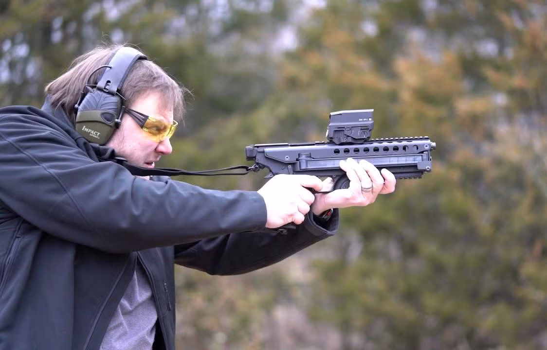 Phần tay cầm, cụm cò súng và hộp tiếp đạn của khẩu súng ngắn P50 liên kết với cụm nòng súng và nắp bệ khóa nòng phía trên bằng một bản lề.