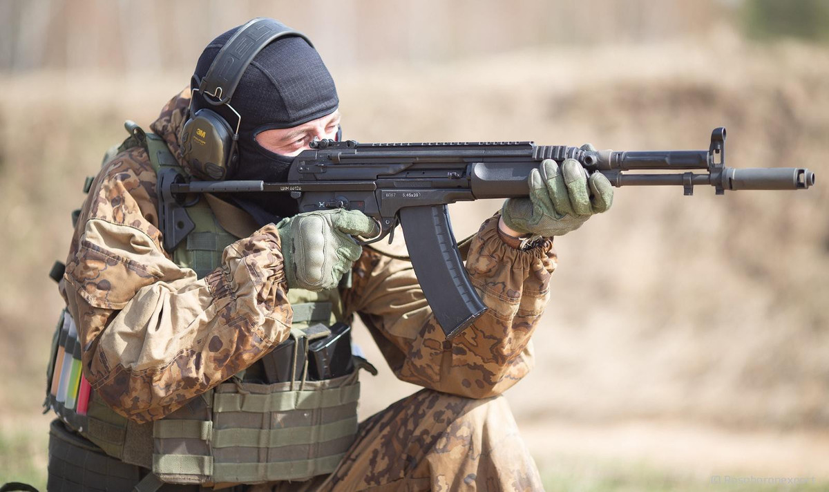 Báng súng được thiết kế để có thể kéo ra và rút lại dễ dàng, từ đó tăng tính hiệu quả trong chiến đấu tùy theo môi trường.