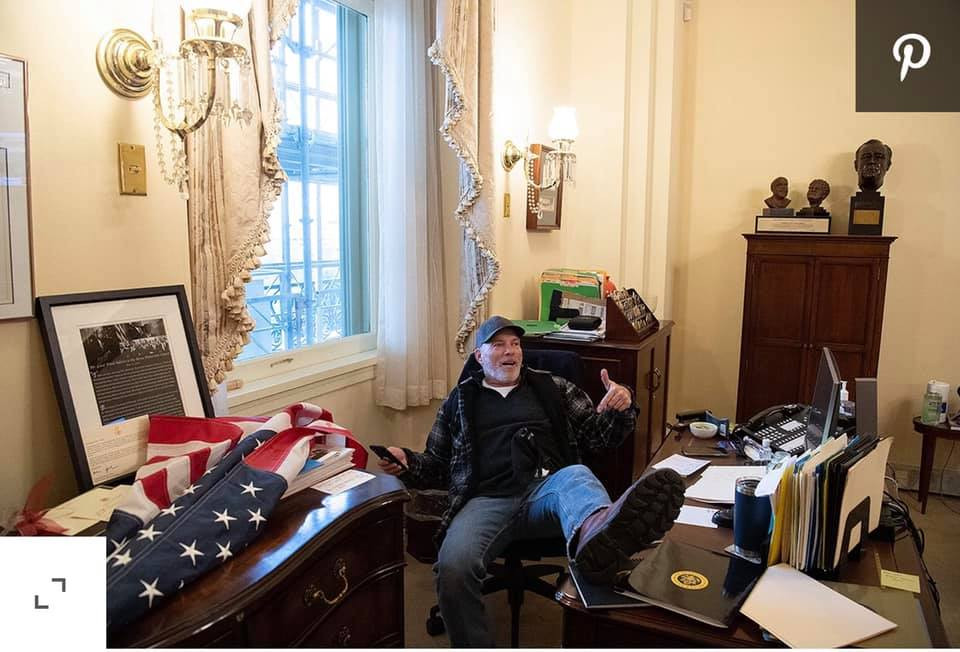 Người biểu tình ủng hộ Tổng thống Donald Trump chiếm phòng Chủ tịch Hạ viện và ngồi gác chân lên bàn làm việc. Nguồn ảnh: BI.