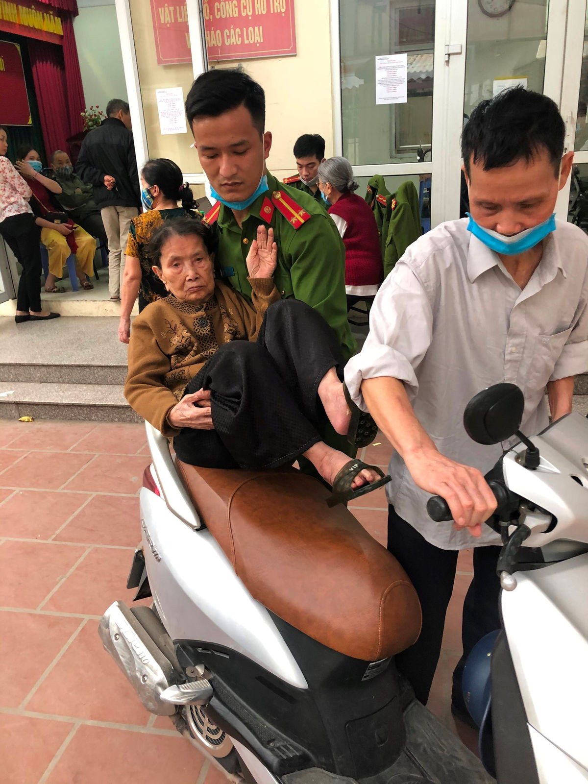 Trung uý Chu Hưng Minh đoàn viên thanh niên Đội Cảnh sát Phòng cháy chữa cháy và cứu nạn cứu - Công an quận Bắc Từ Liêm giúp cụ già khi đến làm CCCD