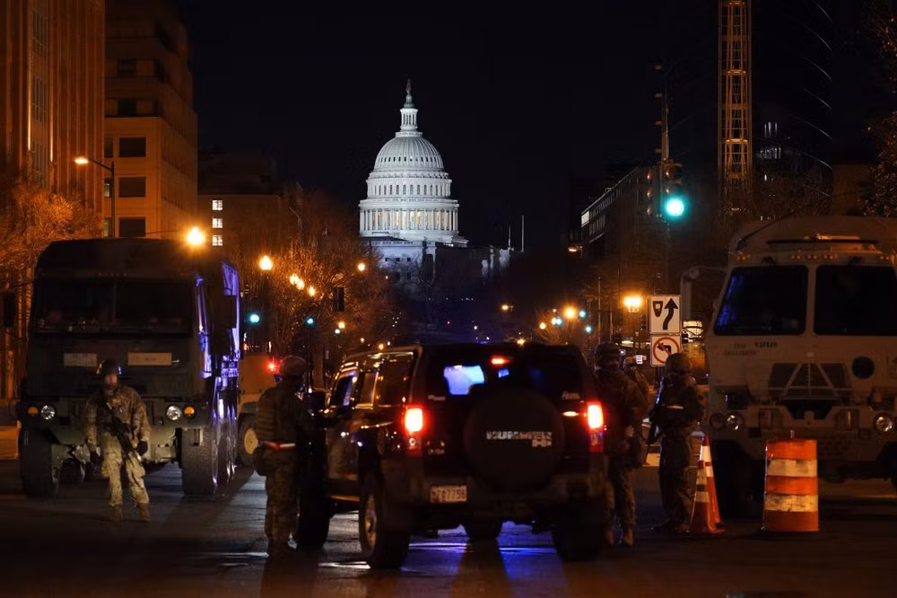 Vệ binh Quốc gia và các xe bọc thép chốt chặn ở một ngã tư dẫn vào Điện Capitol. Sở Mật vụ - cơ quan phụ trách an ninh cho lễ nhậm chức, đã phát đi thông báo cấm Vệ binh Quốc gia đang làm nhiệm vụ ở Washington không được đăng hình ảnh và vị trí của họ lên mạng xã hội. Ảnh: AP.