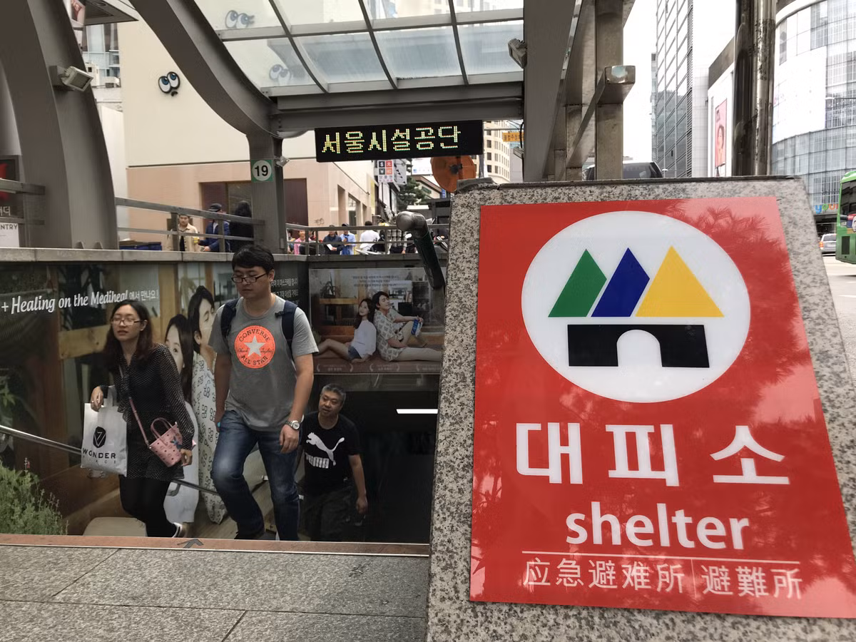 Các lối ra vào ga tàu điện ngầm ở thủ đô Seoul đều có biển báo "hầm trú ẩn" bằng tiếng Hàn, tiếng Anh và tiếng Trung Quốc. Khi xảy ra chiến tranh, các hầm trú ẩn này sẽ là nơi ẩn náu an toàn cho dân chúng trước hỏa lực của đối phương. Nguồn ảnh: Chosul.