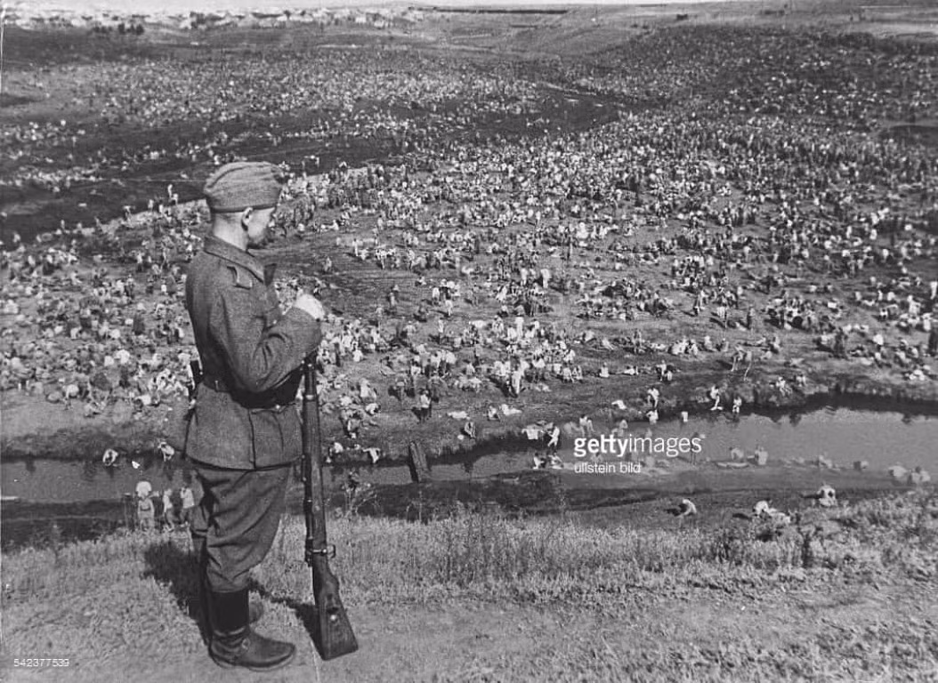 Cho tới tháng 12/1941 - khi mà quân đội Đức buộc phải dừng tiến công trước mùa đông lạnh lẽo của Liên Xô, đã có 2,3 triệu lính Hồng quân đầu hàng, hơn 700.000 lính thiệt mạng và khoảng 1,3 triệu lính bị thương vì nhiều lý do khác nhau. Ảnh: Lính Đức canh gác tù binh Liên Xô ở Ukraine.