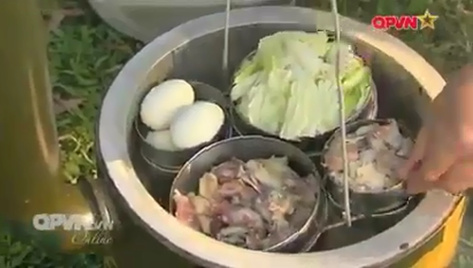 Đồ ăn được cho vào giá, đặt phía bên trên nồi cơm theo để làm chín theo phương pháp hấp cách thủy. Nguồn ảnh: QPVN.