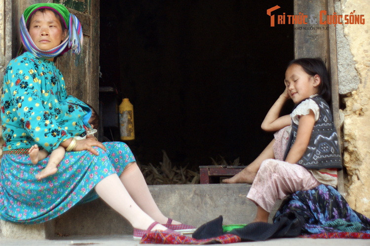 Ba mẹ con bên bậc cửa của ngôi nhà trình tường cũ xưa.