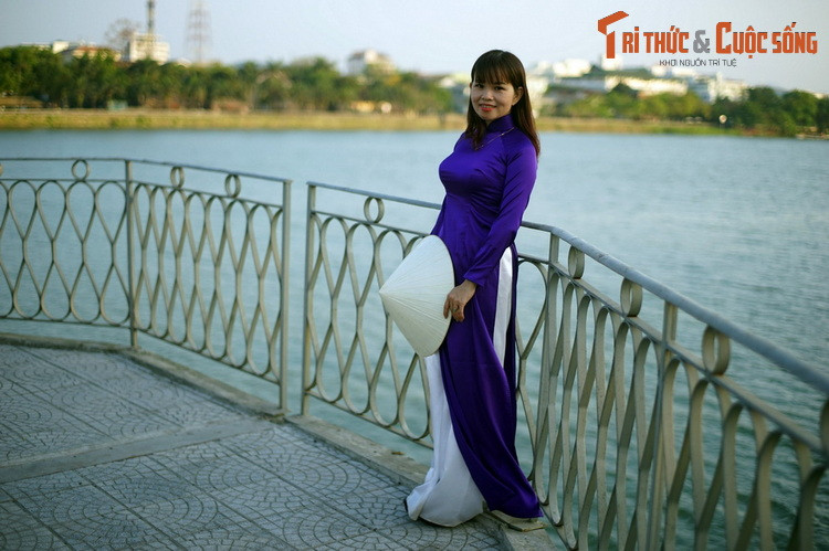 Cô gái mặc áo dài màu tím Huế thả dáng trên cầu Trường Tiền, cây cầu lịch sử nổi tiếng của Cố đô Huế.
