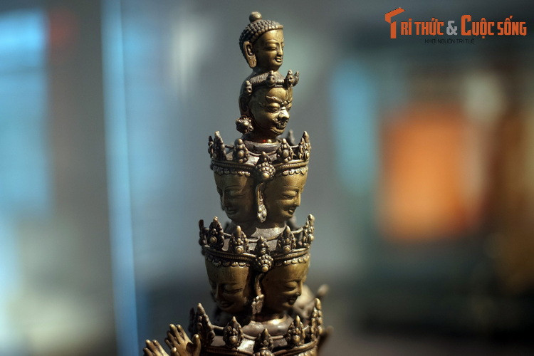 Theo truyền thống Đại thừa, Quán Thế Âm thường được thể hiện kết hợp với Phật A Di Đà. Pho tượng này có Phật A Di Đà ở đỉnh. Dưới đó là một vẻ mặt dữ tợ và 9 khuôn mặt nhân từ.