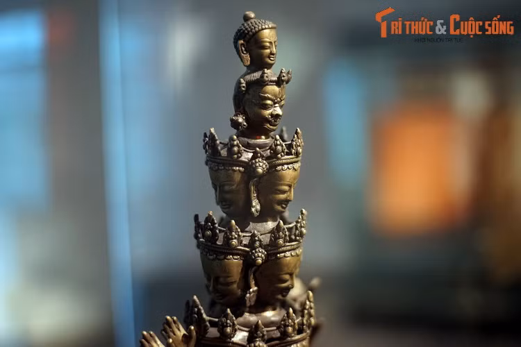 Theo truyền thống Đại thừa, Quán Thế Âm thường được thể hiện kết hợp với Phật A Di Đà. Pho tượng này có Phật A Di Đà ở đỉnh. Dưới đó là một vẻ mặt dữ tợ và 9 khuôn mặt nhân từ.