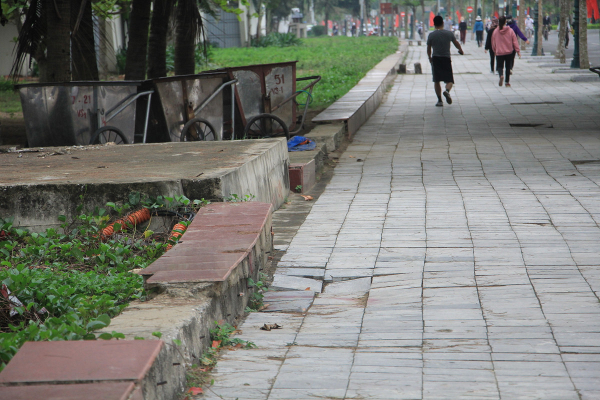 Vỉa hè bị "đánh võng" cao thấp, sụt lún. Bờ rào giữa vỉa hè và bãi tắm bị bong tróc, trơ bê tông.