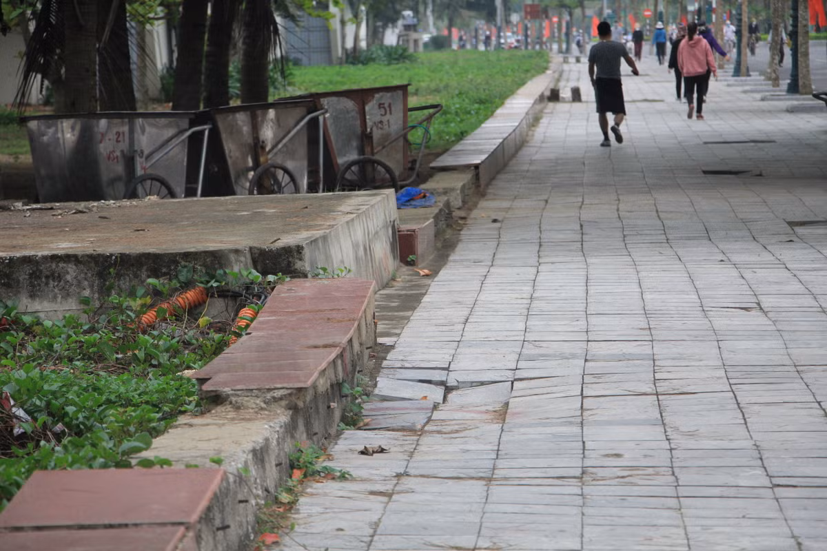 Vỉa hè bị "đánh võng" cao thấp, sụt lún. Bờ rào giữa vỉa hè và bãi tắm bị bong tróc, trơ bê tông.