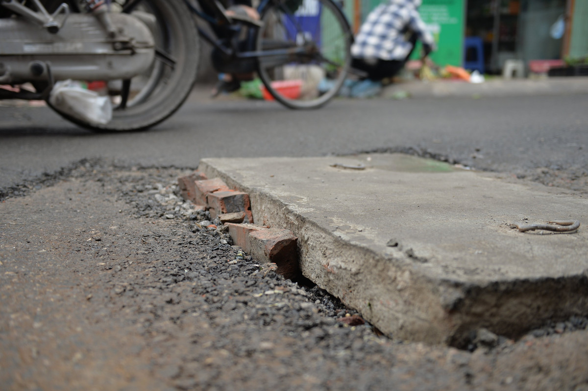 Nhiều hố ga do nằm quá cao so với mặt đường nên người dân phải lấy cát, đá, gạch chèn tạm xung quanh để đỡ nguy hiểm.