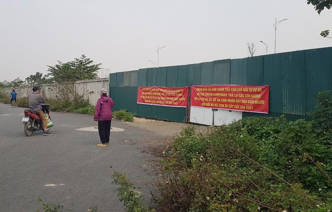 Đỉnh điểm, sáng 26/2, rất đông người dân xã Vân Canh tập trung tại khu vực tường bao để căng băng rôn phản đối và yêu cầu chủ đầu tư khu đô thị tháo dỡ bức tường bê tông chắn lối đi nêu trên.