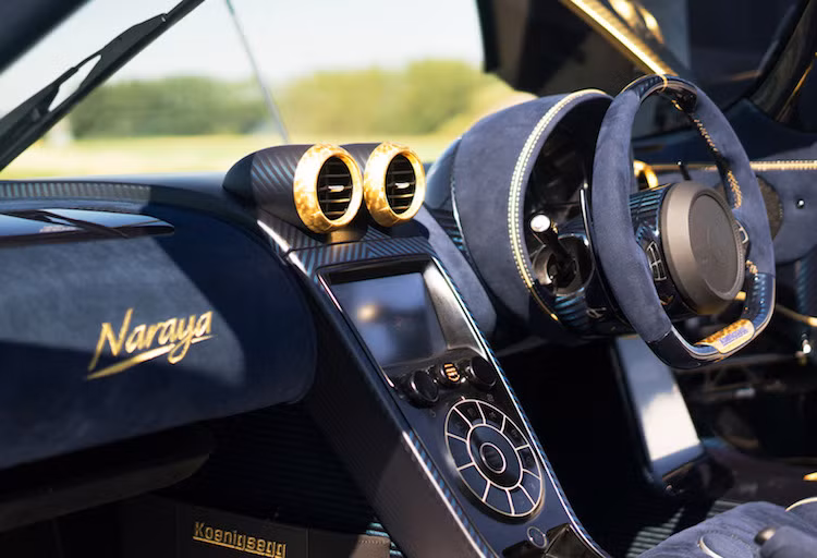 Không dừng lại ở việc dát vàng, độ xa hoa của Naraya còn được thể hiện ở một bảng tên dát tới 155 viên kim cương nhân tạo. Ở bên trong nội thất, chiếc xe cũng có các chi tiết dát vàng và thêu chỉ vàng nổi bật trên nền màu vải Alcantara xanh.