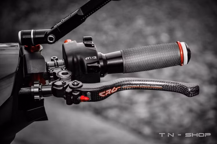 Nằm ở hai bên tay lái của chiếc xe là những cùm công tắc rút gọn Domino, bao tay Rizoma Lux, cùm ga cuốn Domino và đặc biệt là cặp tay phanh/côn đã được nâng cấp lên loại full carbon của hãng CRG từ Mỹ.