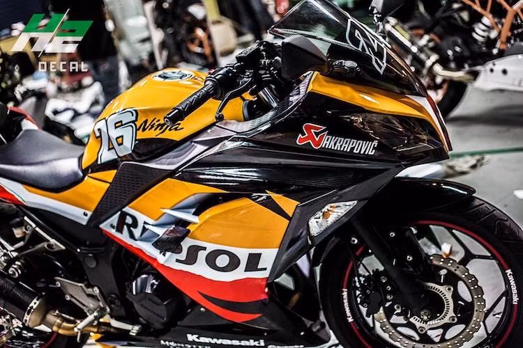 Bên cạnh vỏ xe dán decal in những họa tiết Repsol, một số chi tiết bằng nhựa màu đen trông khá "rẻ tiền" trên Kawasaki Ninja 300 đã được dán decal giả carbon, khiến cho mẫu xe môtô thể thao phân khối lớn tầm trung này trông cao cấp và thể thao hơn.