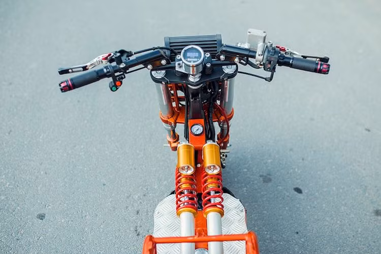 Ở phía trên tay lái của chiếc Zoomer này khá đơn giản với chỉ duy nhất một đồng hồ báo tốc nằm chính giữa cặp ghi-đông clip-on. Nằm hai bên là bao tay Rizoma, cùm công tắc rút gọn và cặp tay phanh đồ chơi.