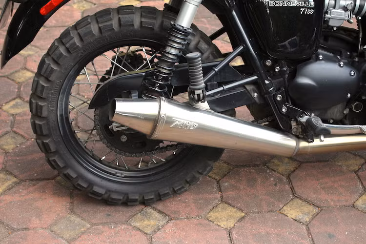 Tuy nhiên so với xe nguyên bản, chiếc Bonneville này có tiếng nổ ấn tượng hơn nhờ vào hệ thống xả với cổ pô không lọc khí thải và pô bằng thép không rỉ của hãng Zard. Bánh sau cũng được nâng lên lốp Continental TKC80, nhưng có bản 140/80/17.