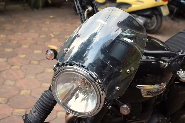 Để chống tạt gió khi đi trên đường rộng, chủ xe đã trang bị cho Bonneville chiếc kính chắn gió trong suốt của Dart. Tuy nhiên với bề mặt kích thước lớn, chiếc kính chắn gió này có kiểu dáng khá giống với những chiếc xe đua scrambler trong quá khứ.